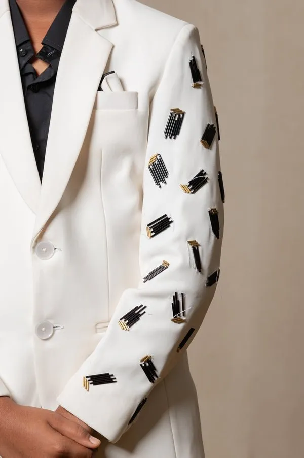 Modern off-white suit with Blackaccents and stylish embroidered sleeve detail, paired with trendy sneakers for a unique, contemporary look